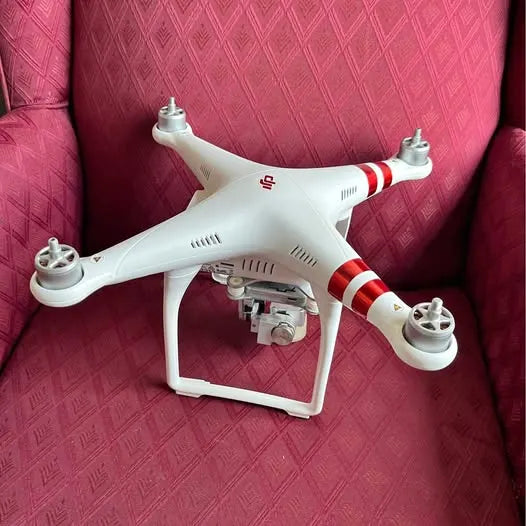 DJI drone with white body and red stripe accents, front camera module exposed