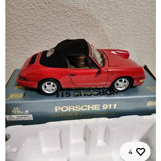 Red 1:14 diecast Porsche 911 Carrera 4 cabriolet model on box with front view