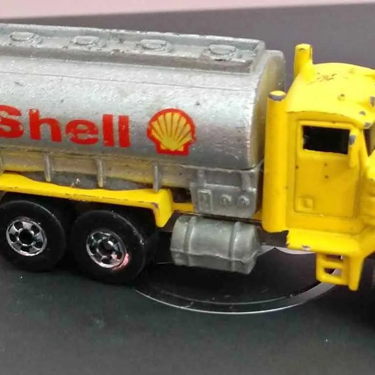 Hot Wheels diecast Shell gas truck with yellow cab and gray fuel tanker, wheels visible