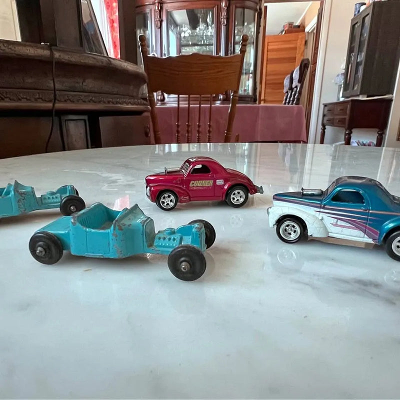 Assorted diecast toy cars, red and teal sports cars with chrome wheels