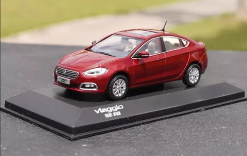 Red diecast sedan model car with front grille and headlights, on display base.