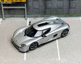 Silver diecast sports racing car model with black hood and rear wing