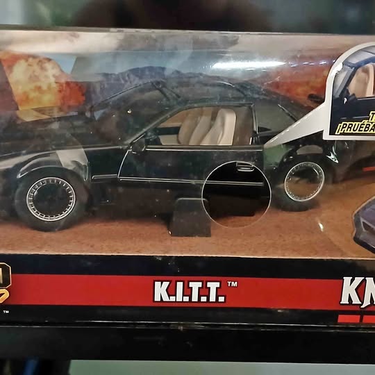 Diecast K.I.T.T car model, dark colored, with front headlights and K.I.T.T stripe