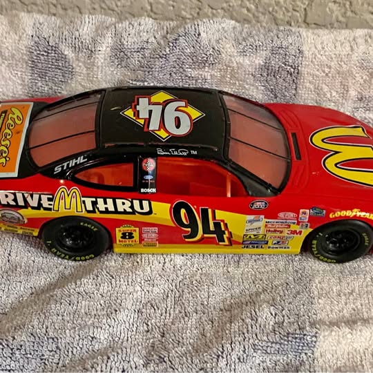 Red NASCAR diecast stock car model, #94 with helmet figure on hood