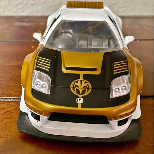 1:24 diecast toy car with gold and black front and clear windshield window