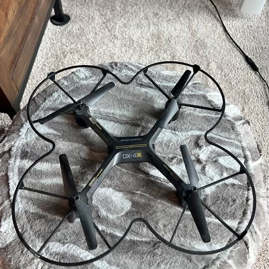 DX-4 drone with four black propellers and gray body