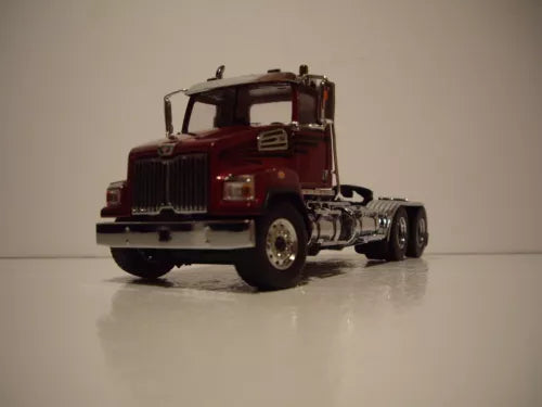 Metallic red die-cast tractor cab model, front view with grille and chrome wheels