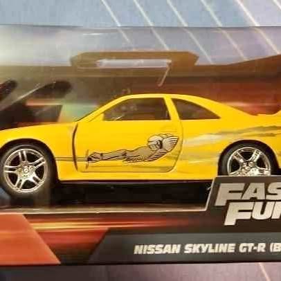 Yellow Nissan Skyline GT-R diecast car with graphic side stripe, 1:32 scale