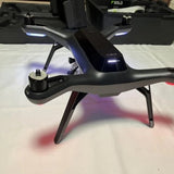Quadcopter drone with GPS, four propeller arms and landing legs, dark gray body