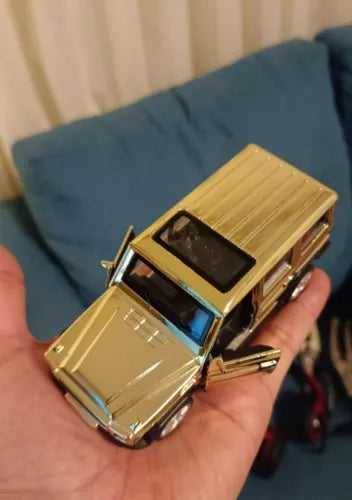 Gold diecast SUV model car with blue-tinted windows, front and side view
