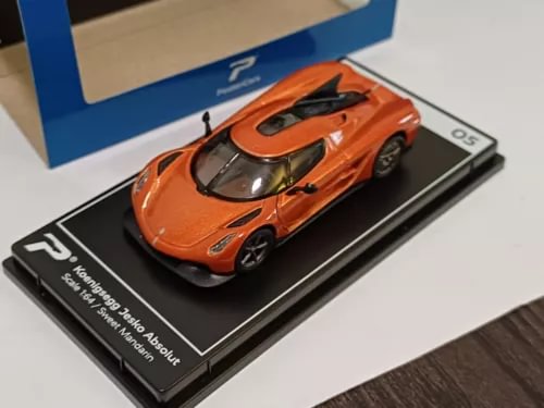 Orange diecast sports car model on black display base