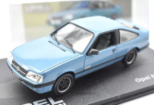 Light blue diecast coupe car model with black wheels, displayed on a branded base
