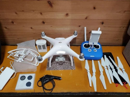 White quadcopter drone with blue remote controller and spare propellers