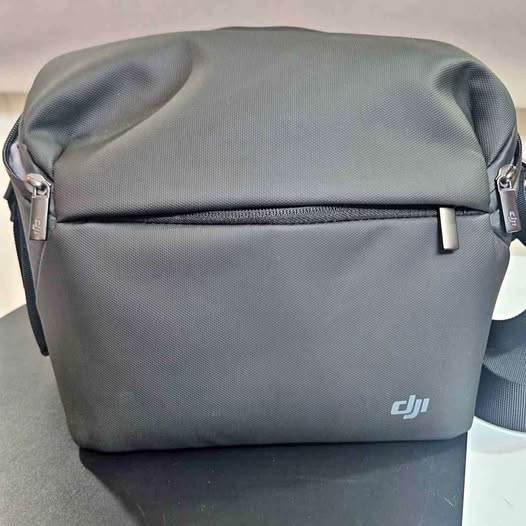 Grey DJI drone shoulder bag with front zipper and carrying handle.