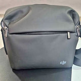 Grey DJI drone shoulder bag with front zipper and carrying handle.