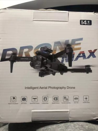 Foldable black quadcopter drone with mounted HD camera on retail box