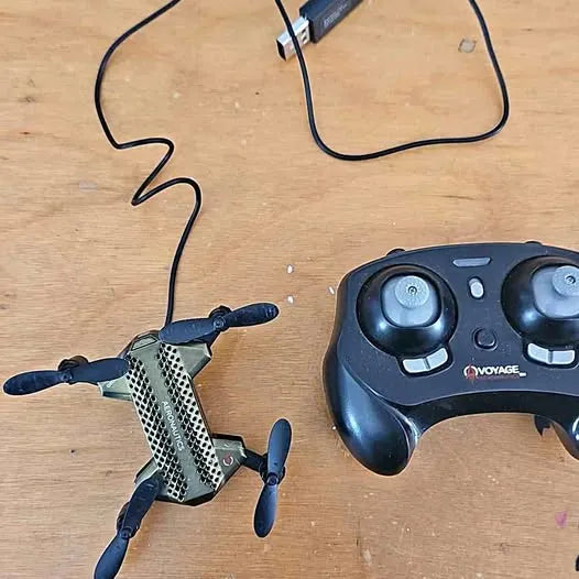 Small quadcopter drone with mesh body and TX game controller