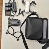 DJI drone accessory kit with folding quadcopter, controller, batteries, charger, carrying bag