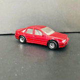 Red vintage diecast car with black tires and silver wheels, side view