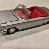 Metallic gray diecast convertible car with red seats and chrome grille