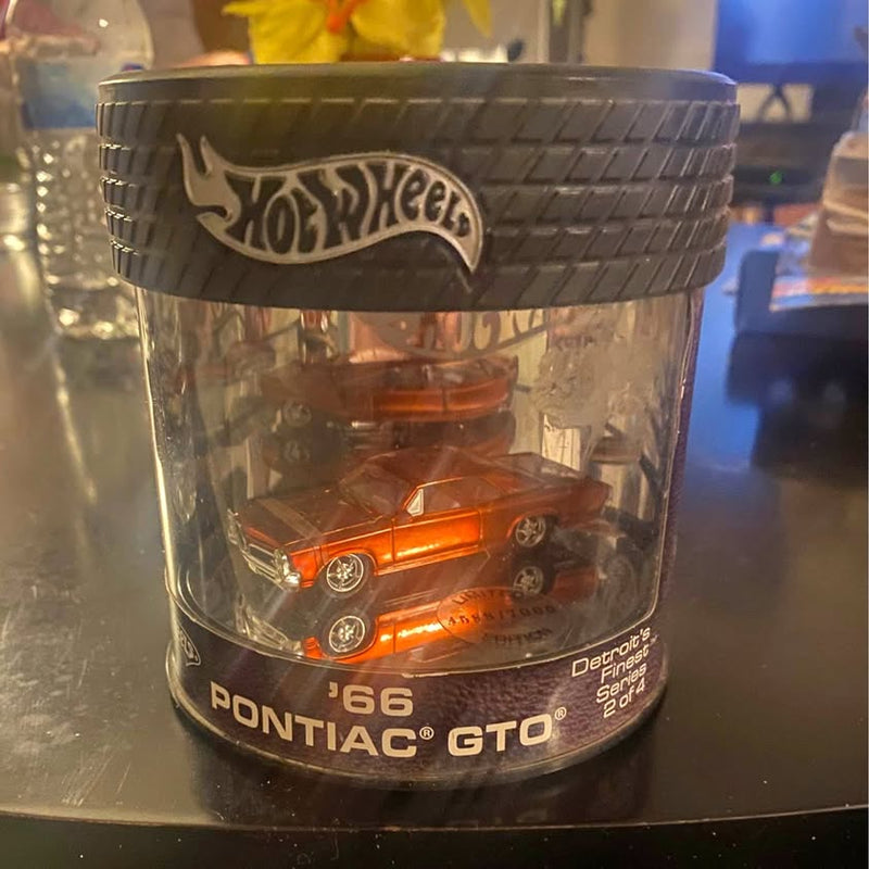 Hot Wheels '66 Pontiac GTO diecast in clear case, orange car with chrome wheels