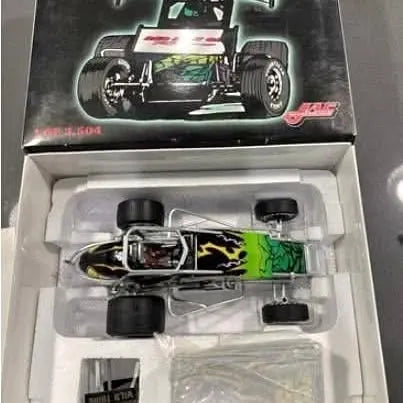 Sprint car diecast model with black and green livery, exposed chassis in display tray