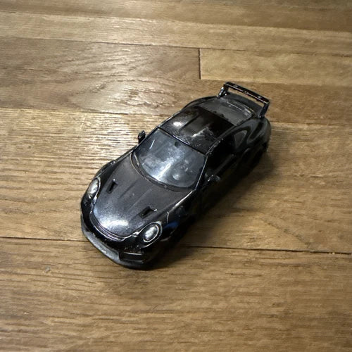 Black diecast toy car model of Porsche 911 GT2 RS, front three-quarter view