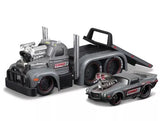 Diecast flatbed trailer model with gray truck bed and black ramps, towing two cars