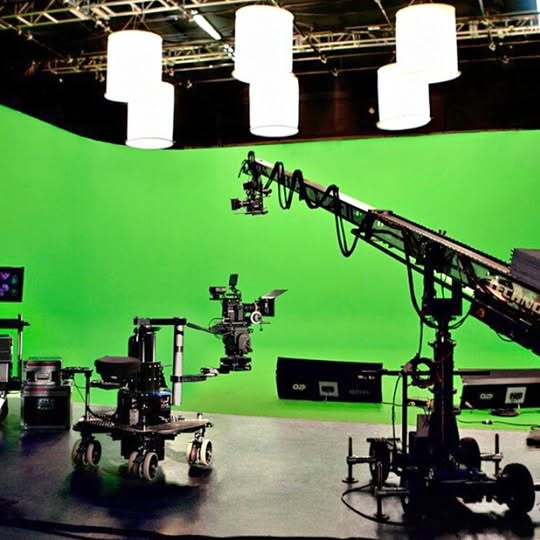 Video production studio setup with green screen and camera crane rig