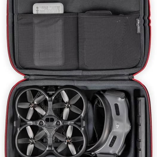 Black hard-shell carrying case with mesh pocket and drone compartment, showing propellers