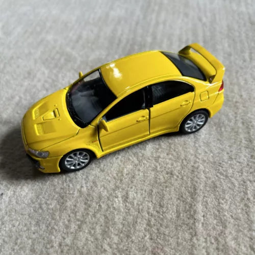 Yellow sports diecast toy car, side view with dark windows and silver wheels