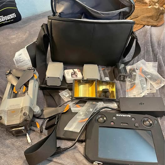Drone with smart controller, remote, batteries and accessory parts laid out