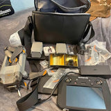 Drone with smart controller, remote, batteries and accessory parts laid out