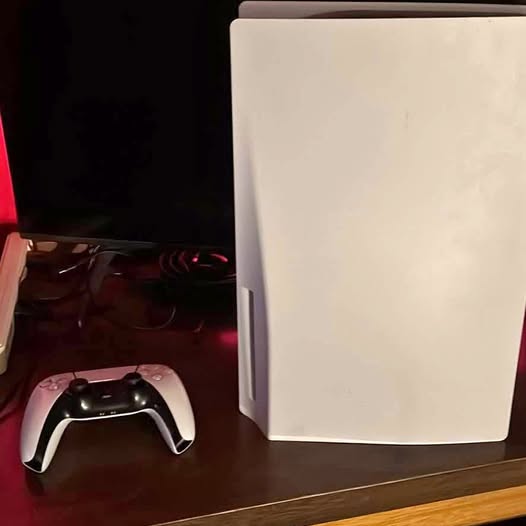 PlayStation 5 console with black wireless controller, white front panel