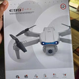 Camera drone on product box, showing quadcopter with blue accents and small action camera