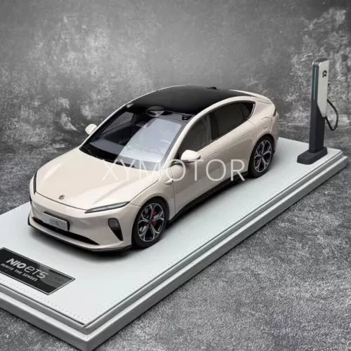 Diecast model car with charging stand, white body, black wheels and tinted windows