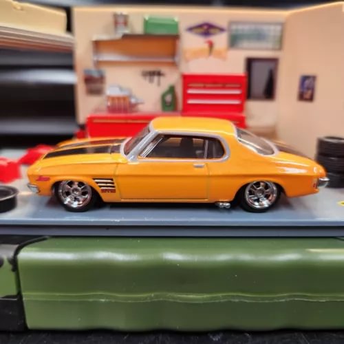 Orange classic coupe diecast model with chrome wheels and window opening detail