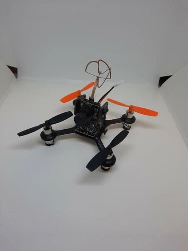 Indoor micro FPV drone with orange arms and four black propellers