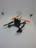 Indoor micro FPV drone with orange arms and four black propellers