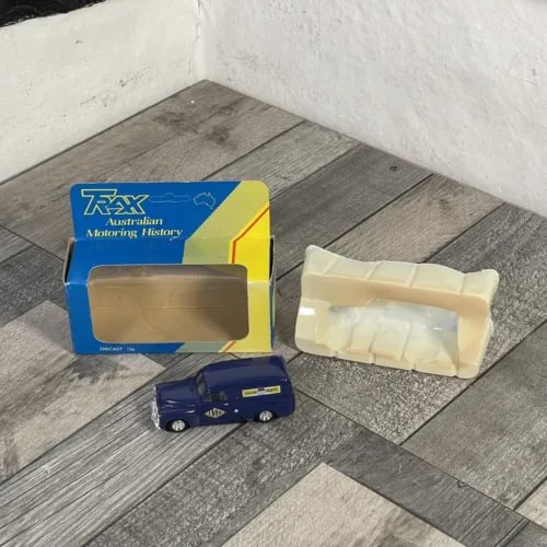 1/43 scale blue diecast van, with yellow-blue storage box and clear display cover