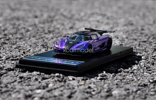 Purple diecast sports car model on black display base, front view, with decals
