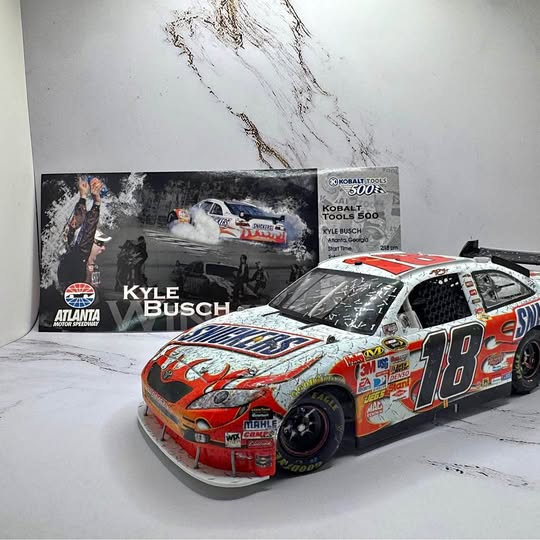 Red and white NASCAR diecast race car, number 18, front three-quarter view