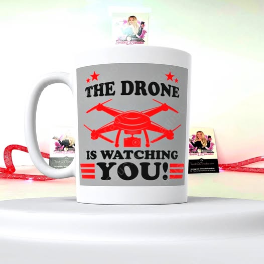 White ceramic coffee mug with red drone graphic and phrase “THE DRONE IS WATCHING YOU”