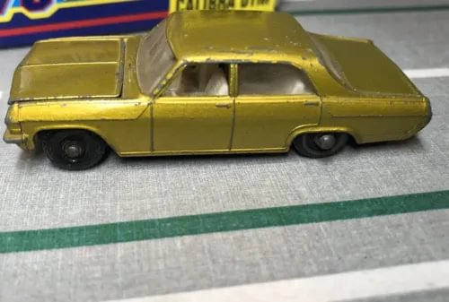 Yellow vintage diecast car with black wheels, side view