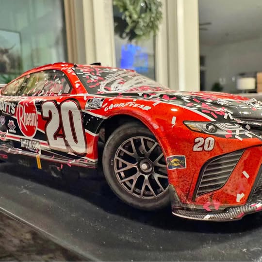 Red NASCAR diecast car model with #20 Rheem and GoodYear graphics, front 3/4 view