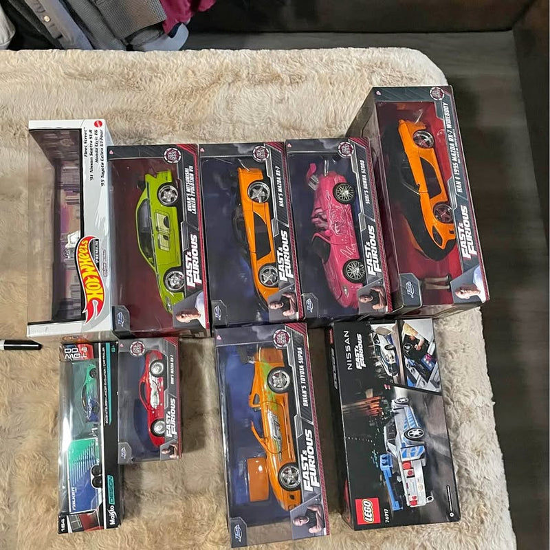 Die-cast car collection in window boxes with orange, green, pink and black cars