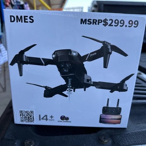 Foldable black quadcopter drone with four propellers, shown on retail box