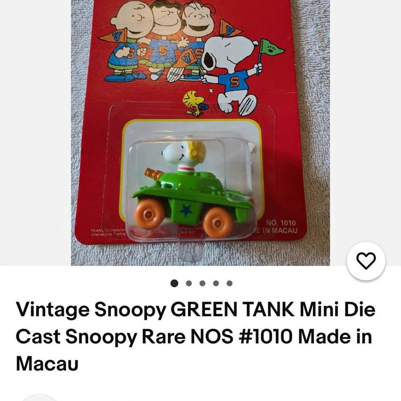 Green mini die-cast toy tank in retail blister pack, Snoopy-themed graphics