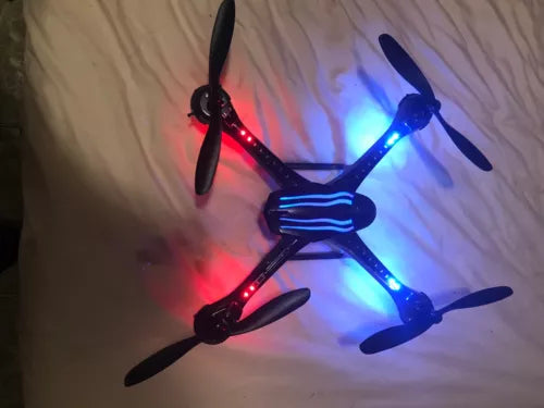 Small LED quadcopter drone with four propellers and red/blue lights