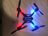 Small LED quadcopter drone with four propellers and red/blue lights
